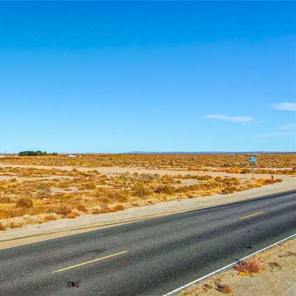 A quiet stretch of highway cutting through the arid desert landscape of Roosevelt, California, where locals often seek the calm of open skies and a trusted Roosevelt dispensary for wellness needs.